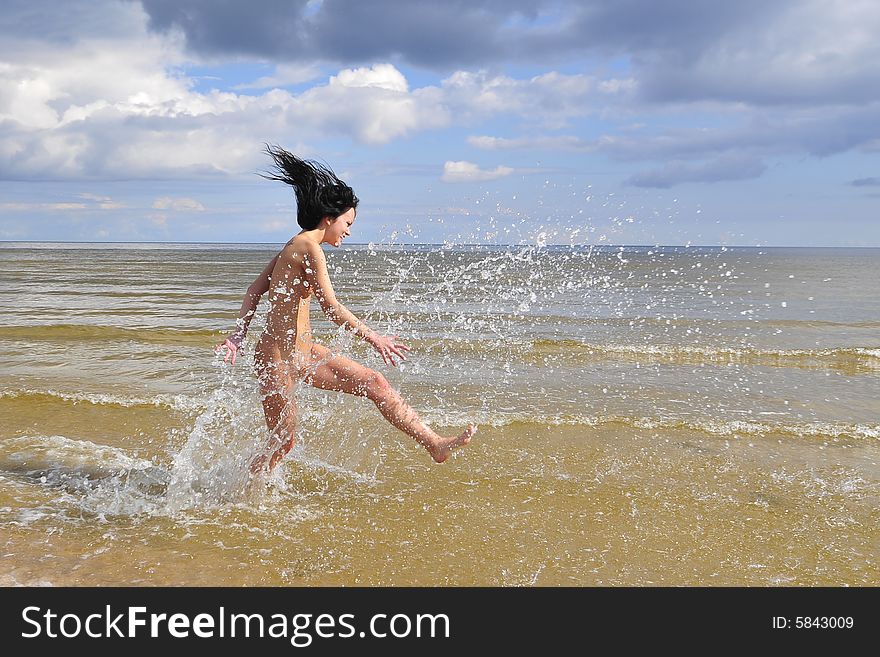 Naked girl running in water