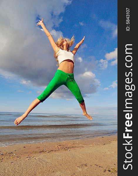 Jumping girl on a backgground of a blue sky