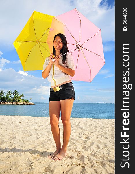 Smiling girl on the beach with two umbrellas. Smiling girl on the beach with two umbrellas.