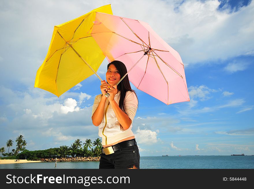 Smiling girl on the beach with two umbrellas. Smiling girl on the beach with two umbrellas.