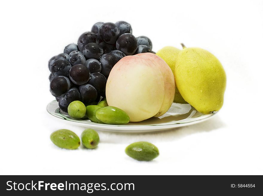Grape,peach,pear  and olive in a dish on white background