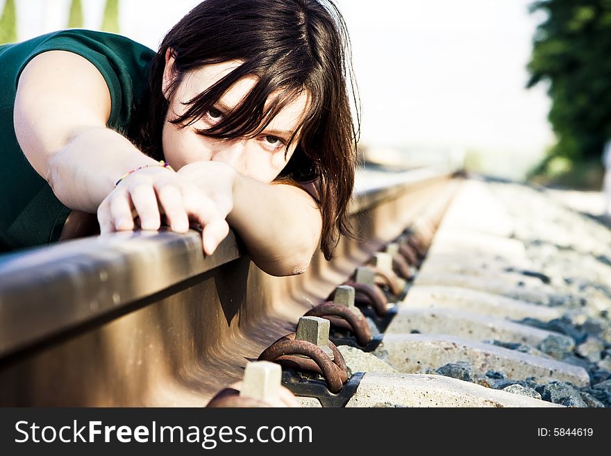 Sad young woman laying on the railway. Sad young woman laying on the railway.