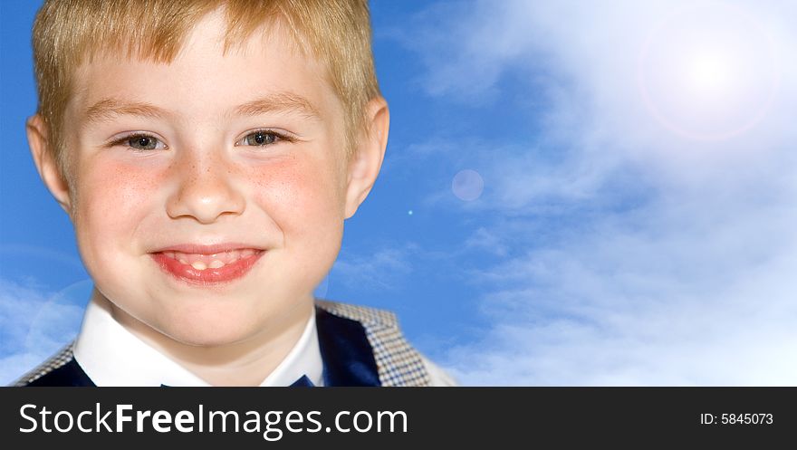 Cute smiling 5-year-old boy against blue sky background. Cute smiling 5-year-old boy against blue sky background