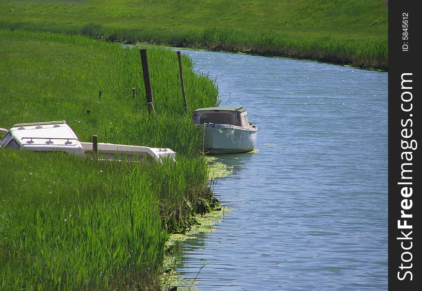 Boat on the blue river just before the riverbend, one tilted boat in the tall green grass

*RAW format available
. Boat on the blue river just before the riverbend, one tilted boat in the tall green grass

*RAW format available