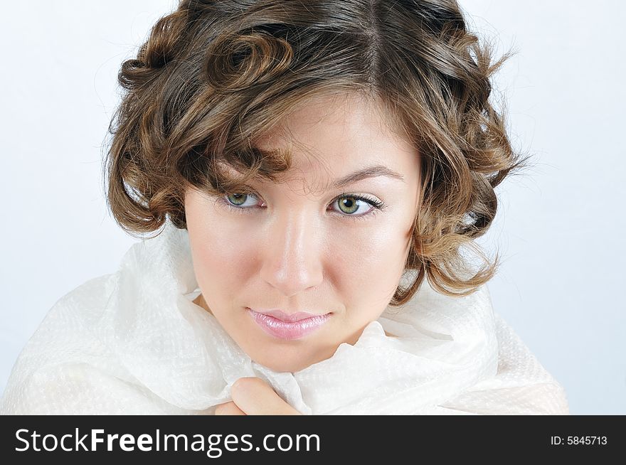 Portrait of the beauty girl muffled in white shawl