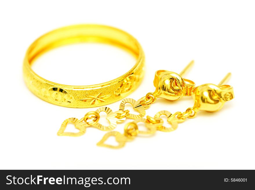 A golden ring and earrings isolated on white background.