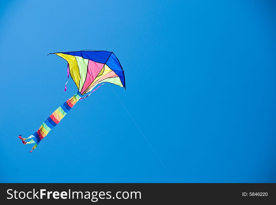 Image of a kite isolated against the blue sky. Image of a kite isolated against the blue sky