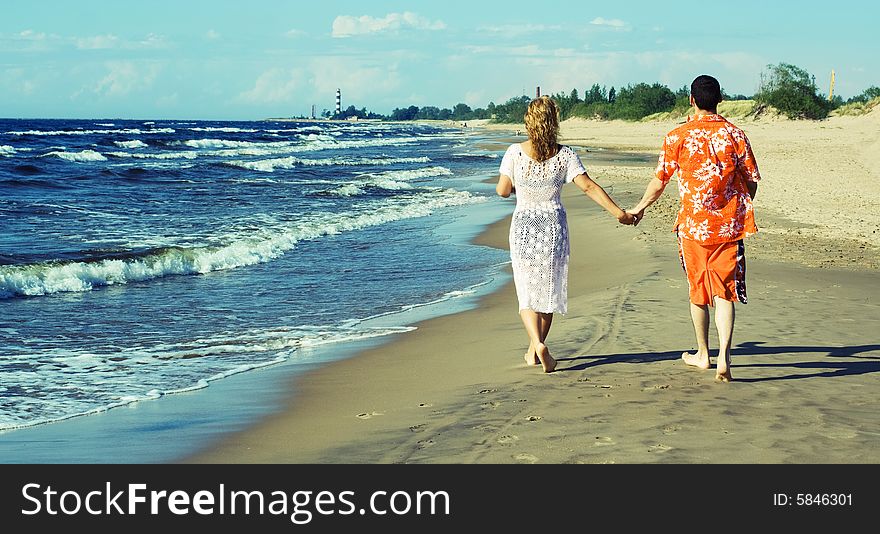 Young couple walking on the beach.