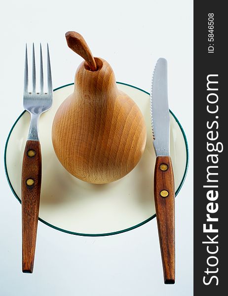 A wooden pear on a plate