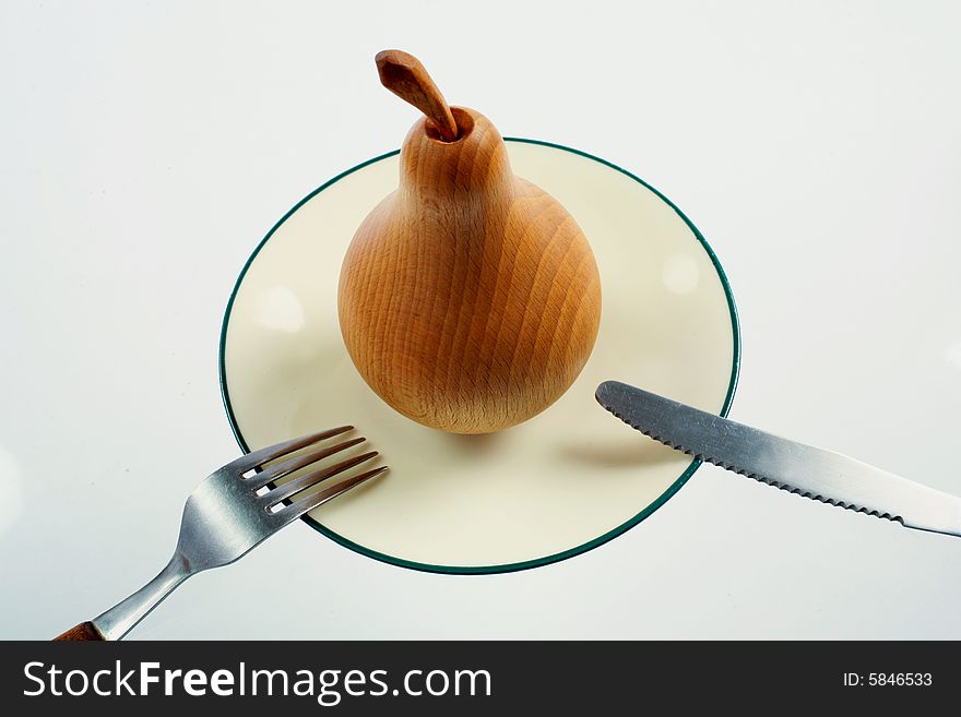 A wooden pear on a plate