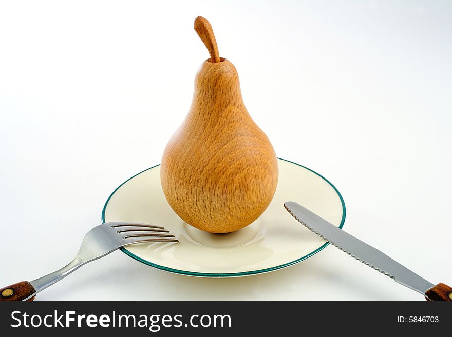 A wooden pear on a plate