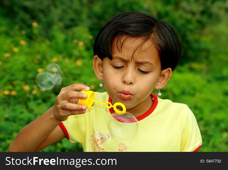 A girl actively releasing soap bubbles. A girl actively releasing soap bubbles.