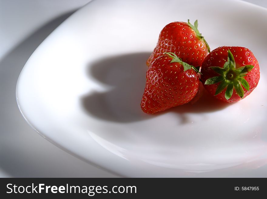 Three strawberry on white plate