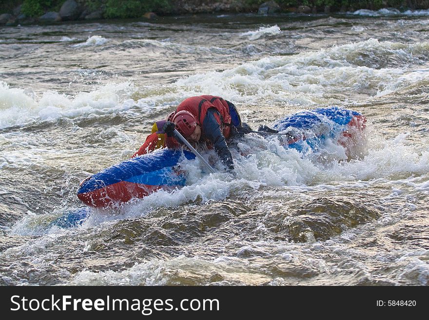 Sportsmen on the blue catamaran in the rapid