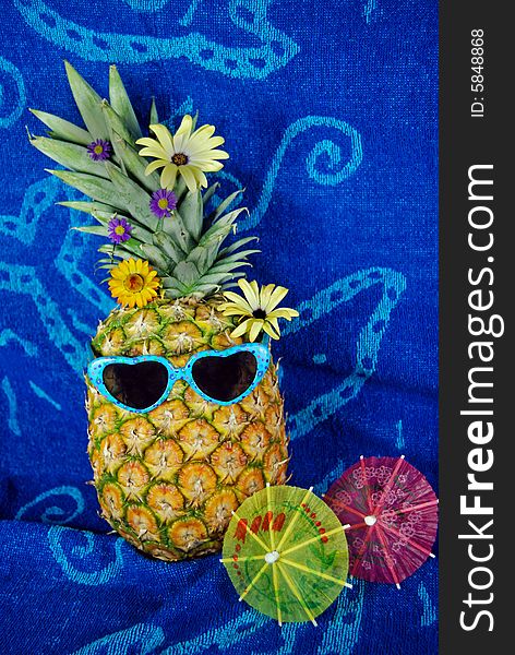 Pineapple wearing sunglasses on a beach towel. Pineapple wearing sunglasses on a beach towel.