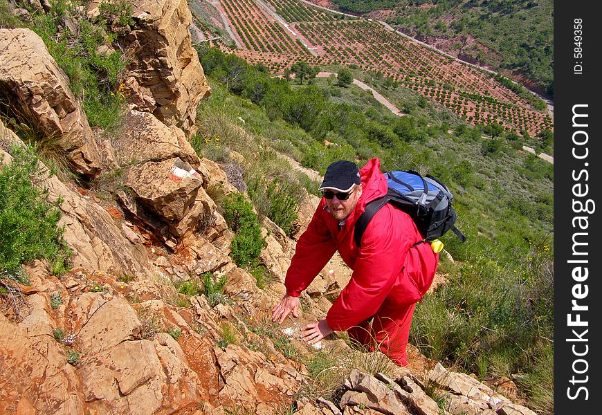 The man in red jacket climbing in small mountains. The man in red jacket climbing in small mountains.