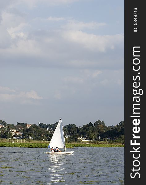 Man and woman sailing in distance. Picture taken from back. Vertially framed photo. Man and woman sailing in distance. Picture taken from back. Vertially framed photo.