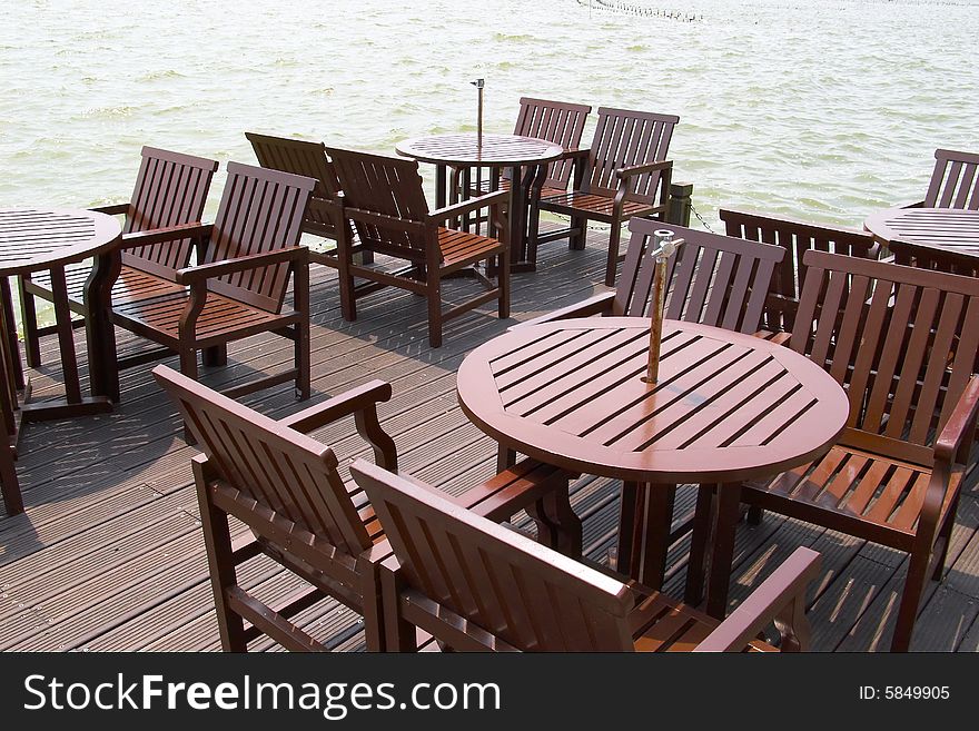 The table and chair are in the by the lake.