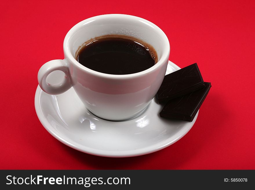 White coffee cup on red background with chocolate. White coffee cup on red background with chocolate
