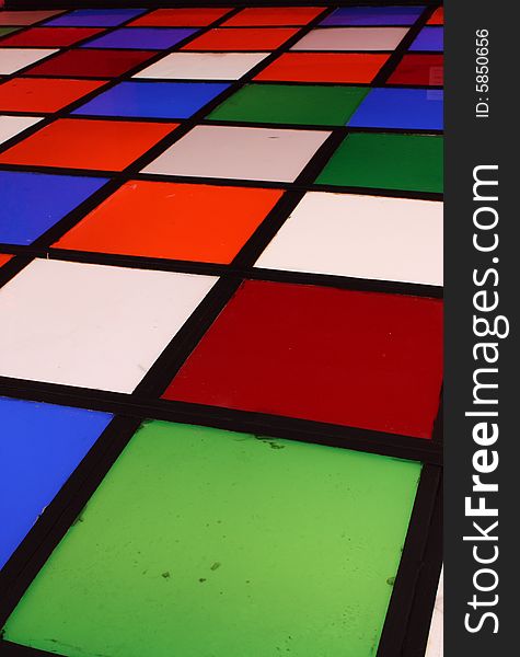 Disco dancing floor in bright colored up lit squares within a black grid. Disco dancing floor in bright colored up lit squares within a black grid.