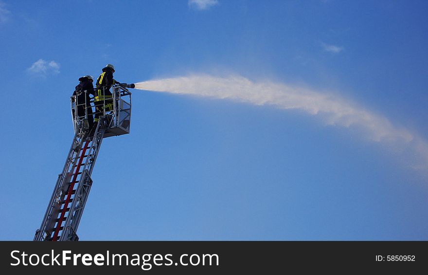 Two fire Fighters standing on a ladder