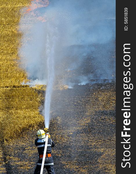 A firefighter extinguish the burning stubble field