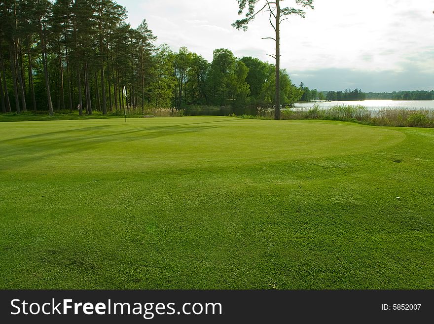 Open lakeside golf landscape on the late afternoon. Open lakeside golf landscape on the late afternoon