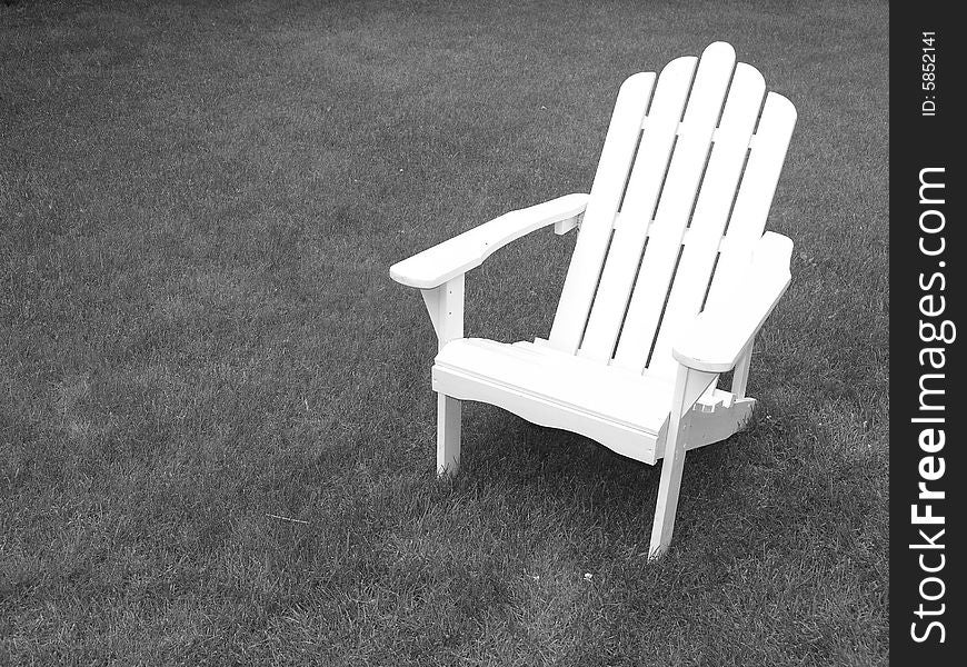 Single white adirondack chair isolated over grass