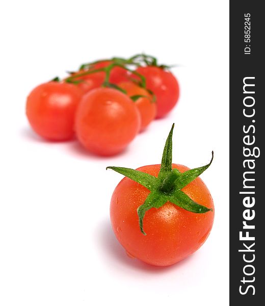Cherry tomatoes together and one of that is alone, on a white background