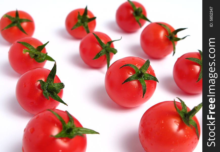 Cherry tomatoes together forming a line on a white background