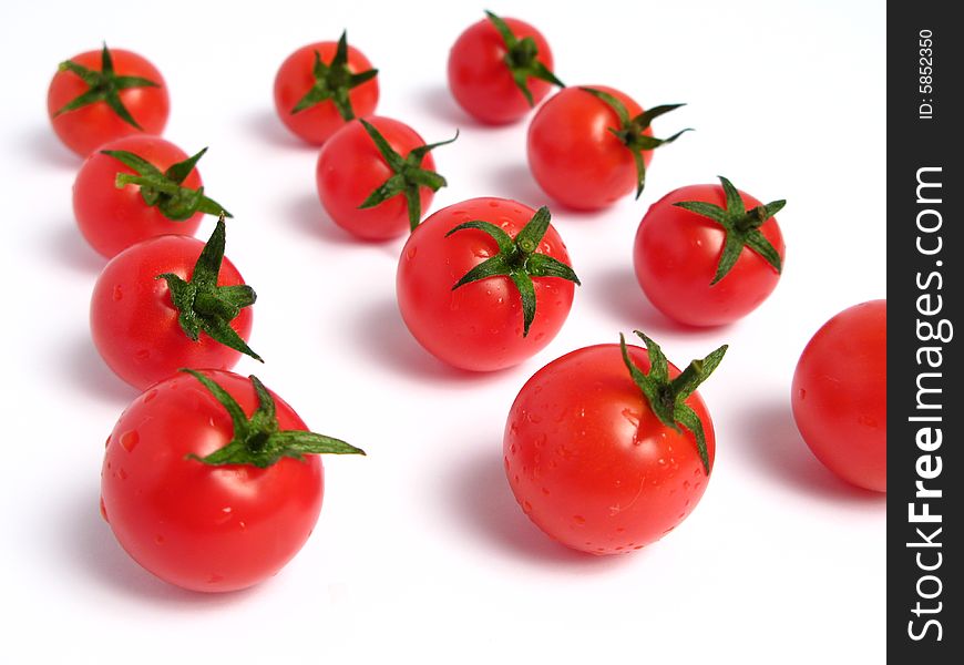 Cherry tomatoes together forming a line on a white background