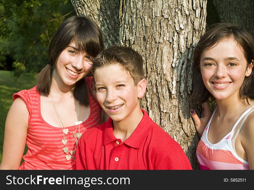 Three youngsters under some trees with pensive, faraway looks on their faces. Three youngsters under some trees with pensive, faraway looks on their faces.