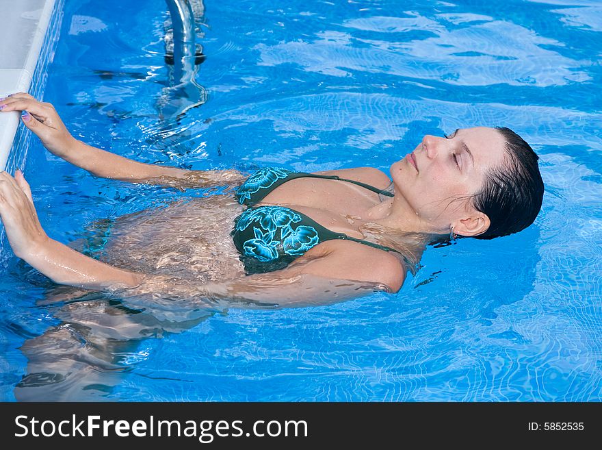 A beautiful woman relaxing in the pool.