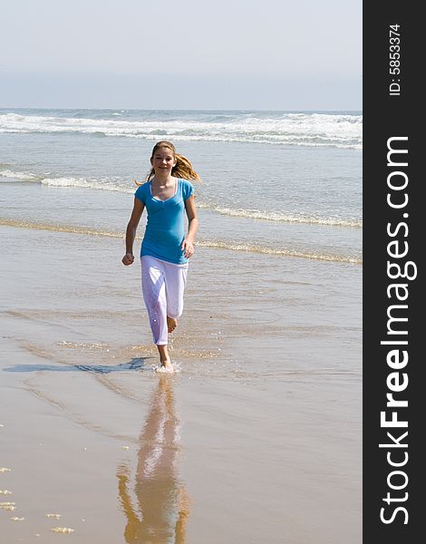 Young Teen Girl Running along the Ocean shore. Young Teen Girl Running along the Ocean shore