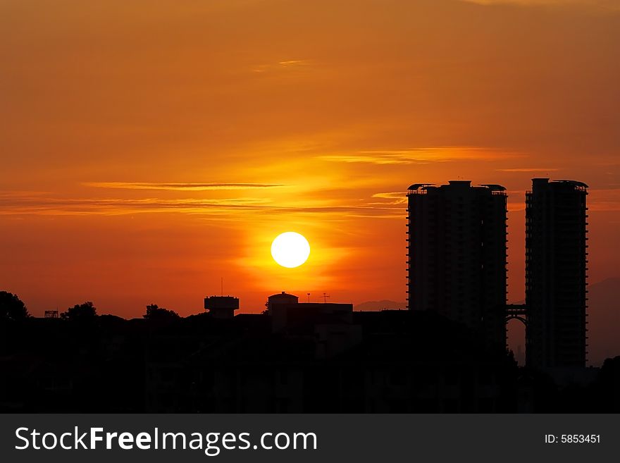 Golden sunrise cityscape with twin tower condominium.