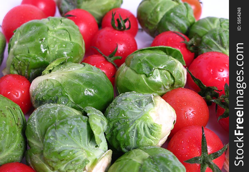 Fresh organic Brussels sprouts and cherry tomatoes, on white background. Fresh organic Brussels sprouts and cherry tomatoes, on white background