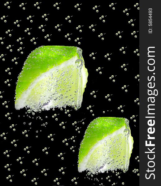 A fresh background with two pieces of lemon in a black and bubbles background. A fresh background with two pieces of lemon in a black and bubbles background