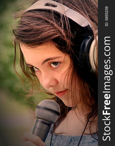 Young beautiful teen girl singing in microphone. Young beautiful teen girl singing in microphone