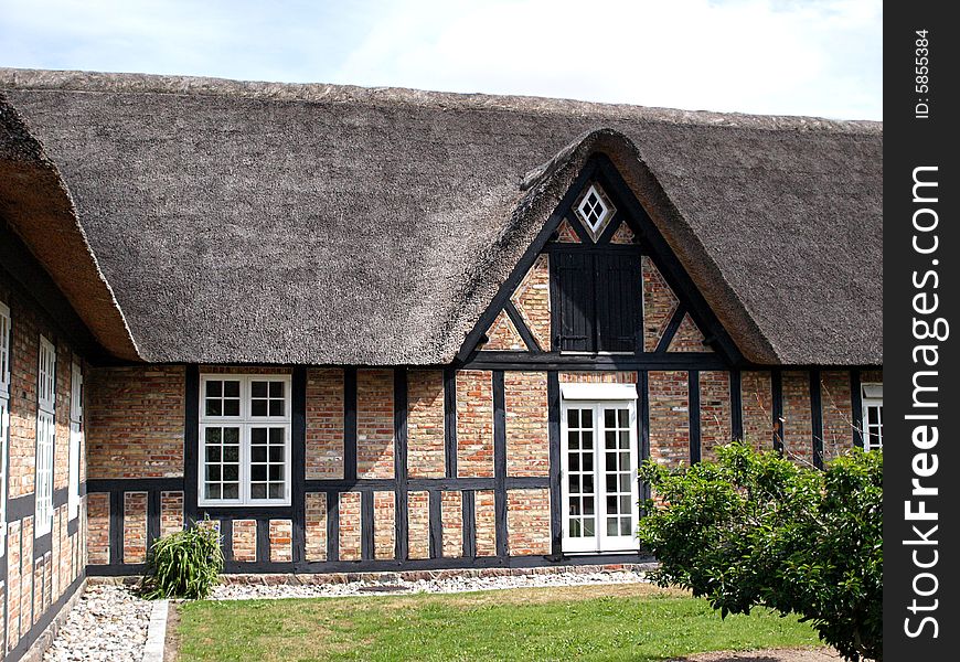 Traditional country farmhouse with old style thatched straw roof in Denmark. Traditional country farmhouse with old style thatched straw roof in Denmark