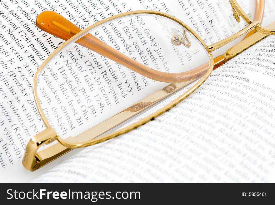 Glasses lying on an open book - close up. Glasses lying on an open book - close up