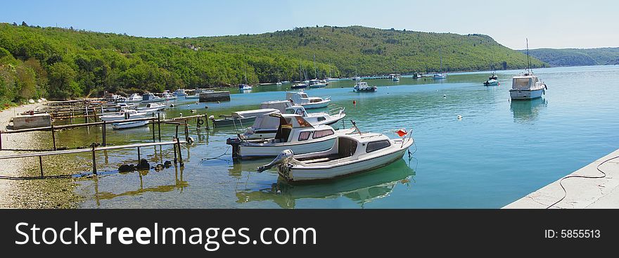 Bay panorama with fishing boats in the harbour, beautiful landscape Trget in Rasa Bay (Istria - Croatia) - suitable as card,postcard,tourism-related poster *panorama stitched with 2 horizontal images