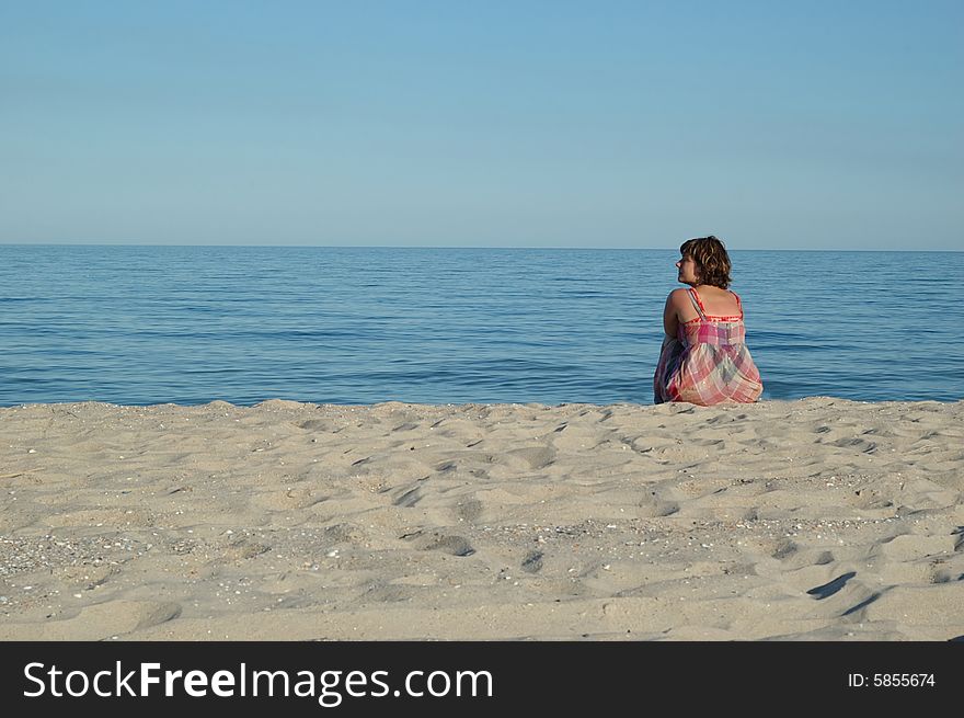 Young woman is sitting on the seashore. Young woman is sitting on the seashore