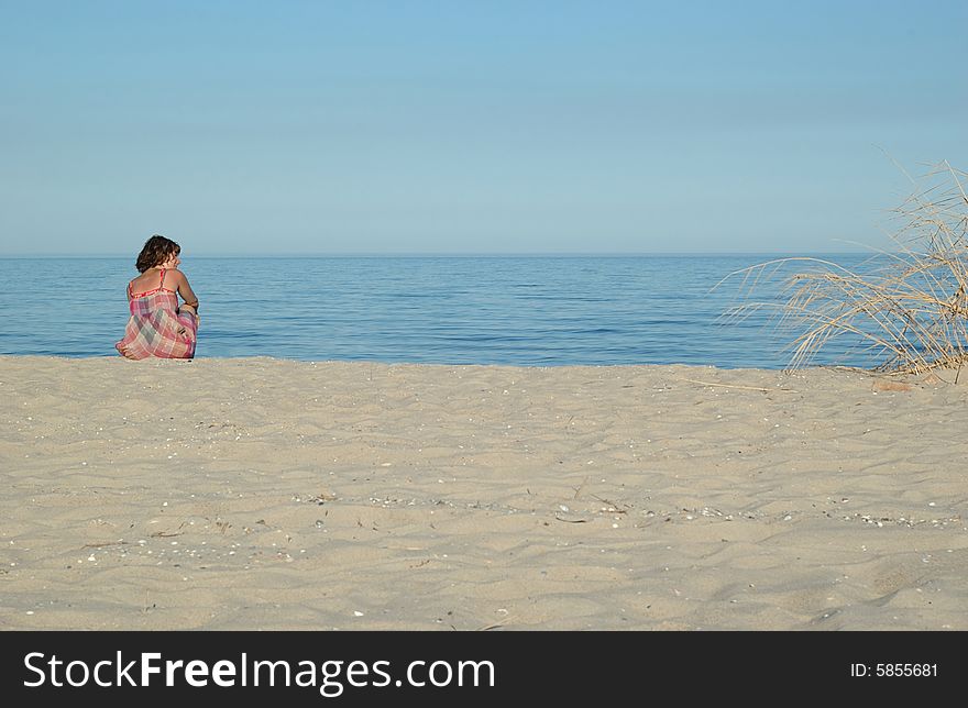 Young woman is sitting on the beach (2)