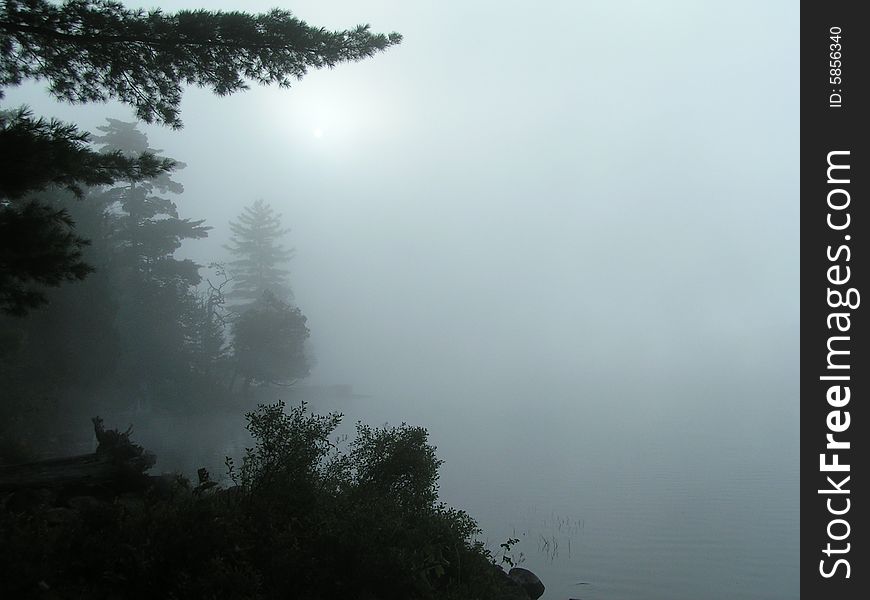Foggy mist over lake in Adirondacks as the sun rises.