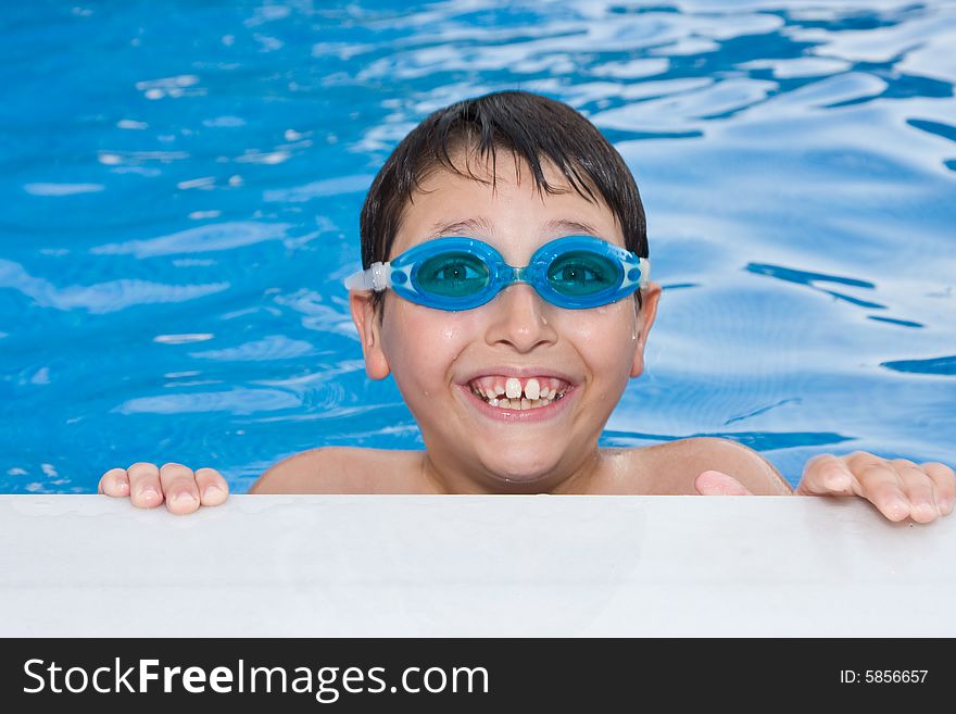 Boy swimming in the pool with goggles.