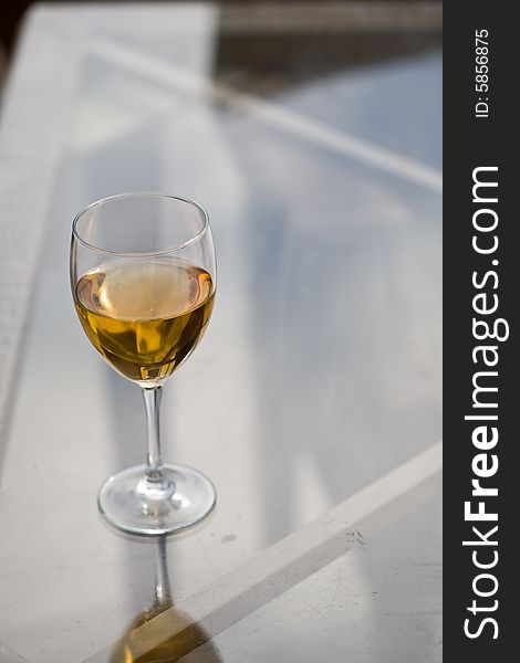 Glass of dry white wine on the glass table. Glass of dry white wine on the glass table