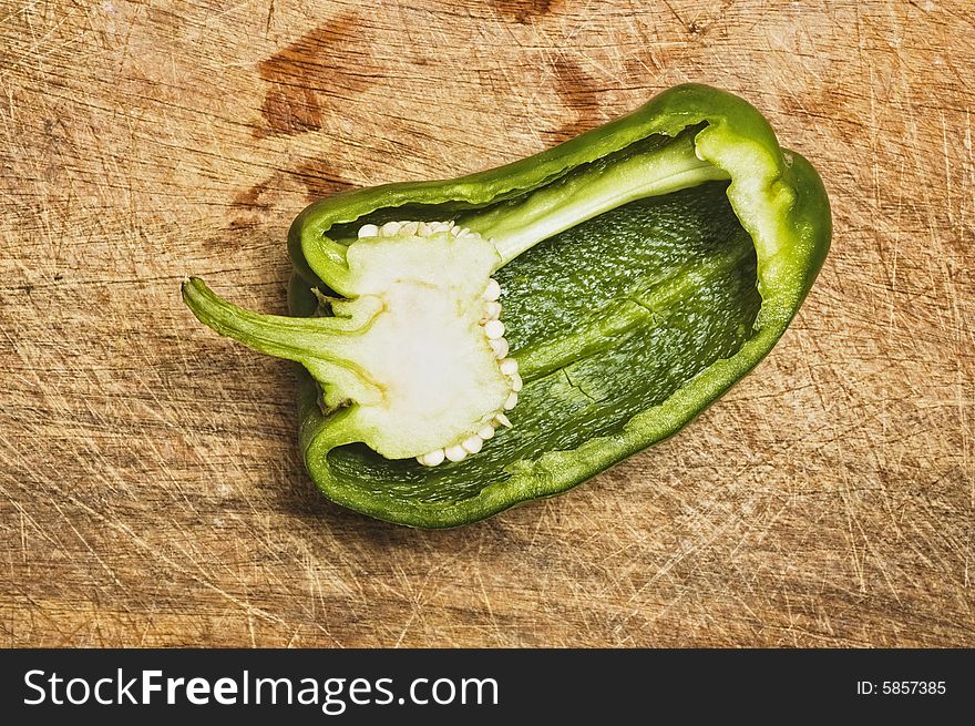 Green bell pepper on old cutting table.