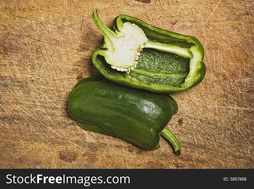 Green bell pepper on old cutting table.