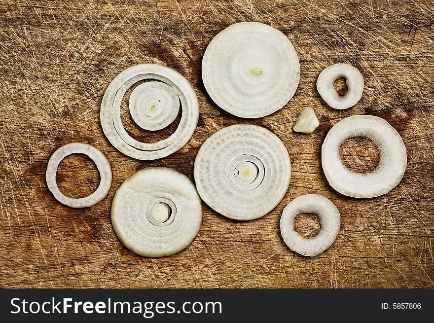 Onion rings on old wooden cutting table. Onion rings on old wooden cutting table.