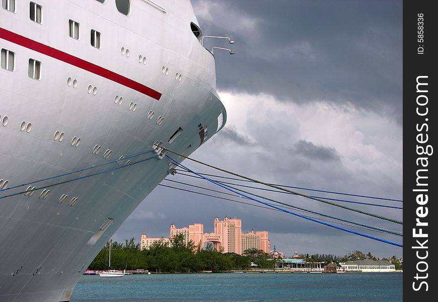 The front of a huge cruise liner with resort building on Paradise Island in a background (The Bahamas). The front of a huge cruise liner with resort building on Paradise Island in a background (The Bahamas).